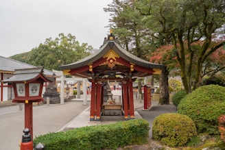 a red and gold gazebo in a park area