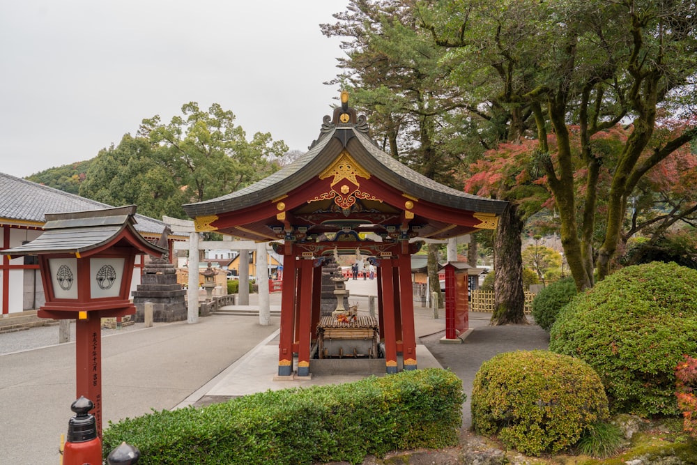 a red and gold gazebo in a park area