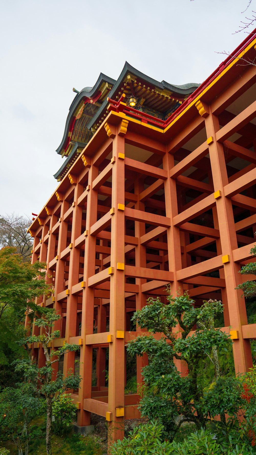 a tall building with a red roof surrounded by trees