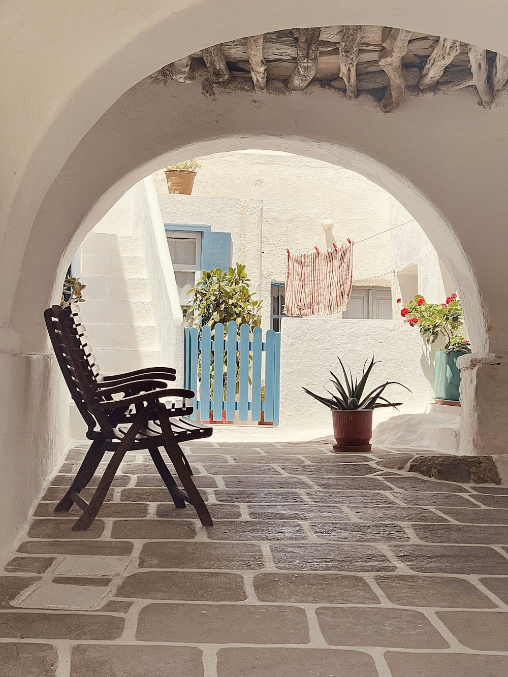 un patio avec une chaise et des plantes en pot