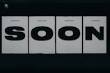 a black and white photo of a sign that says soon