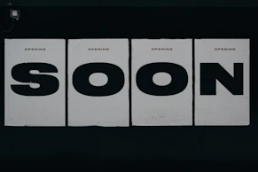 a black and white photo of a sign that says soon