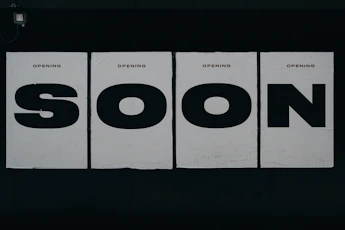 a black and white photo of a sign that says soon