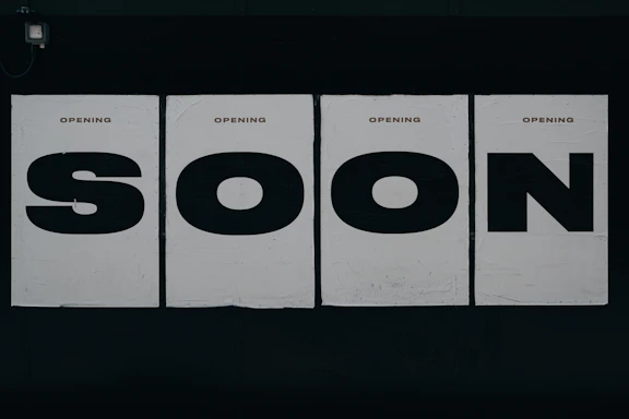 a black and white photo of a sign that says soon