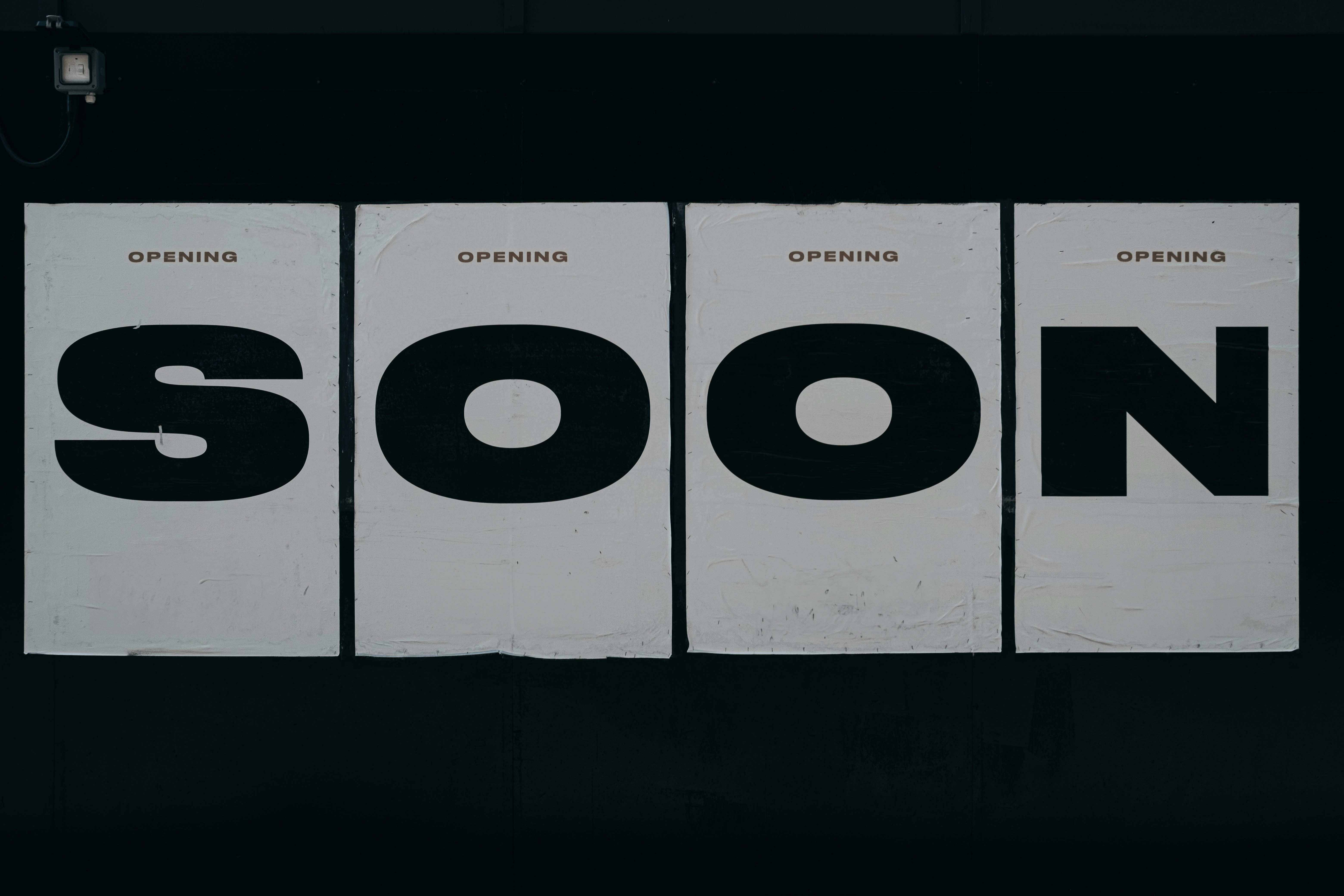 a black and white photo of a sign that says soon