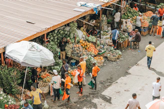 A vibrant market scene with colorful stalls and fresh tropical fruits under bright sunlight.