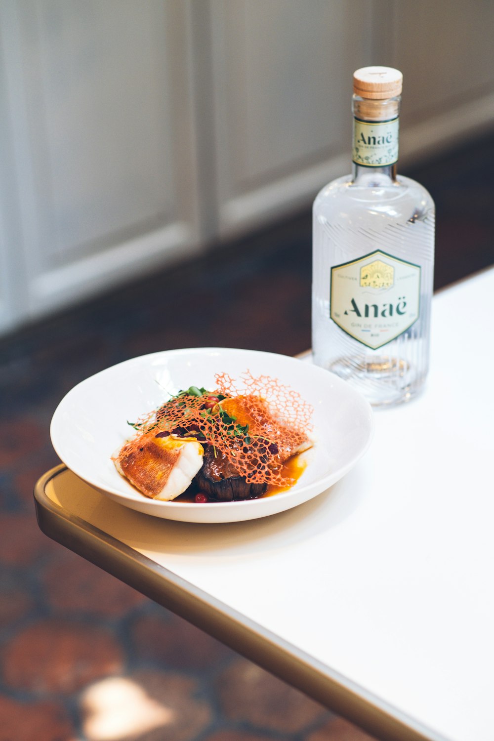 a white plate topped with food next to a bottle of alcohol