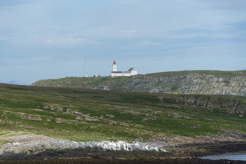 a lighthouse on top of a hill near a body of water