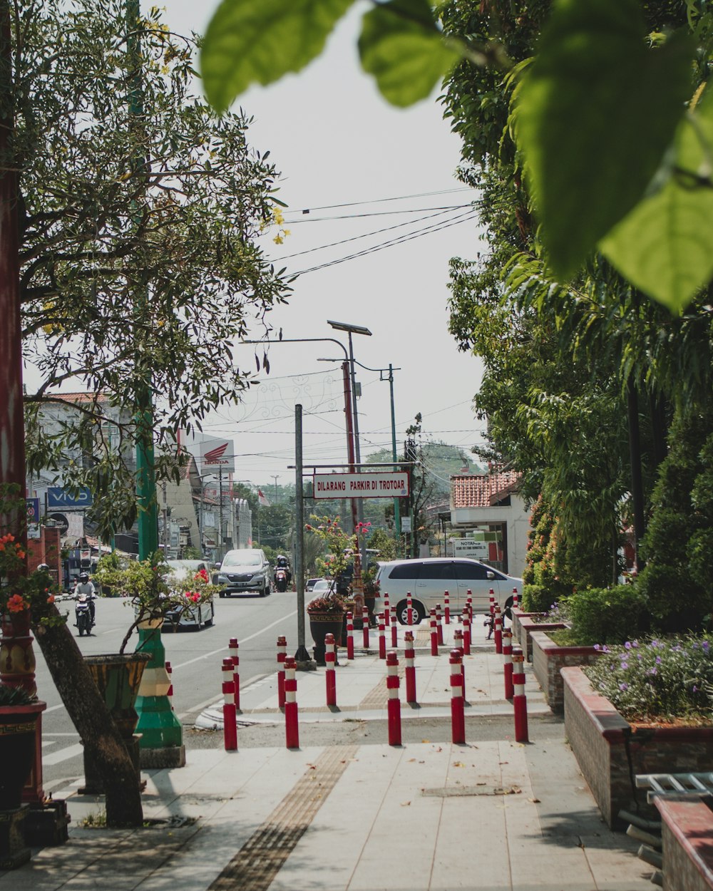 a city street with red and white cones on the sidewalk