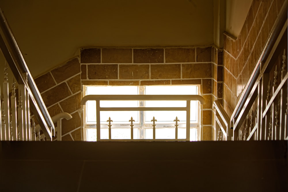 eine Treppe mit Geländer, die zu einem Fenster führt