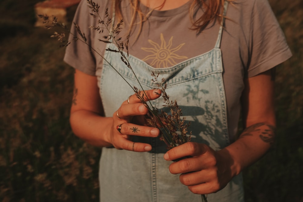 a woman holding a bunch of flowers in her hands