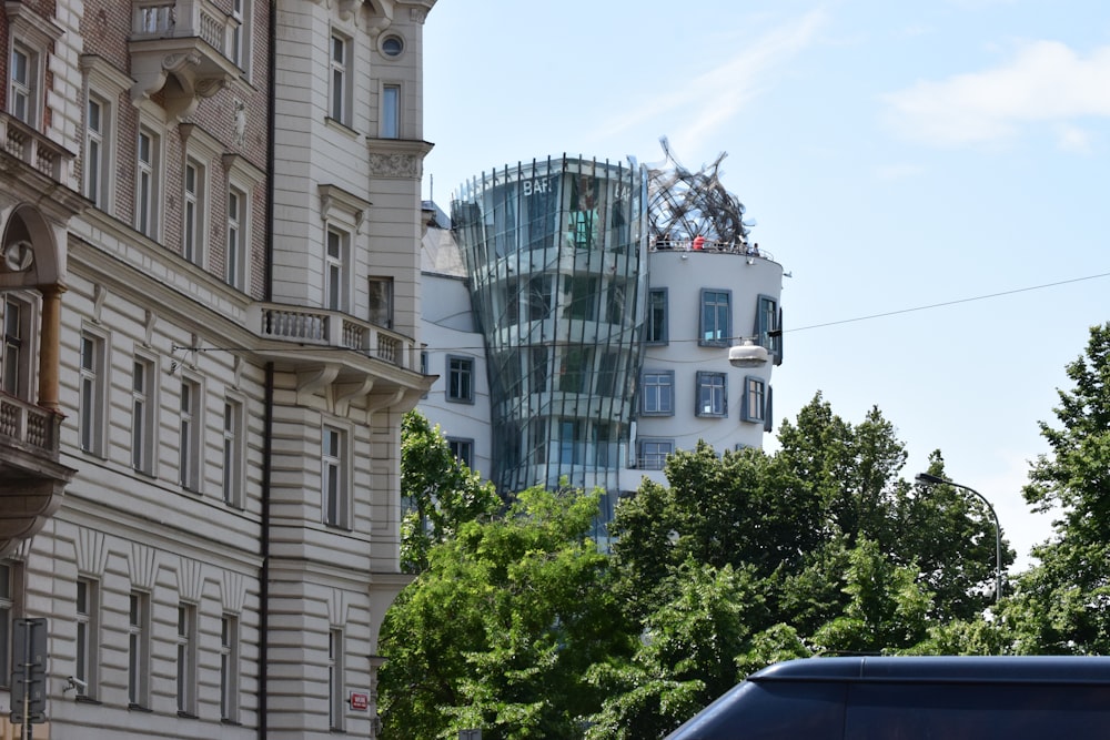 a blue truck driving past a tall white building