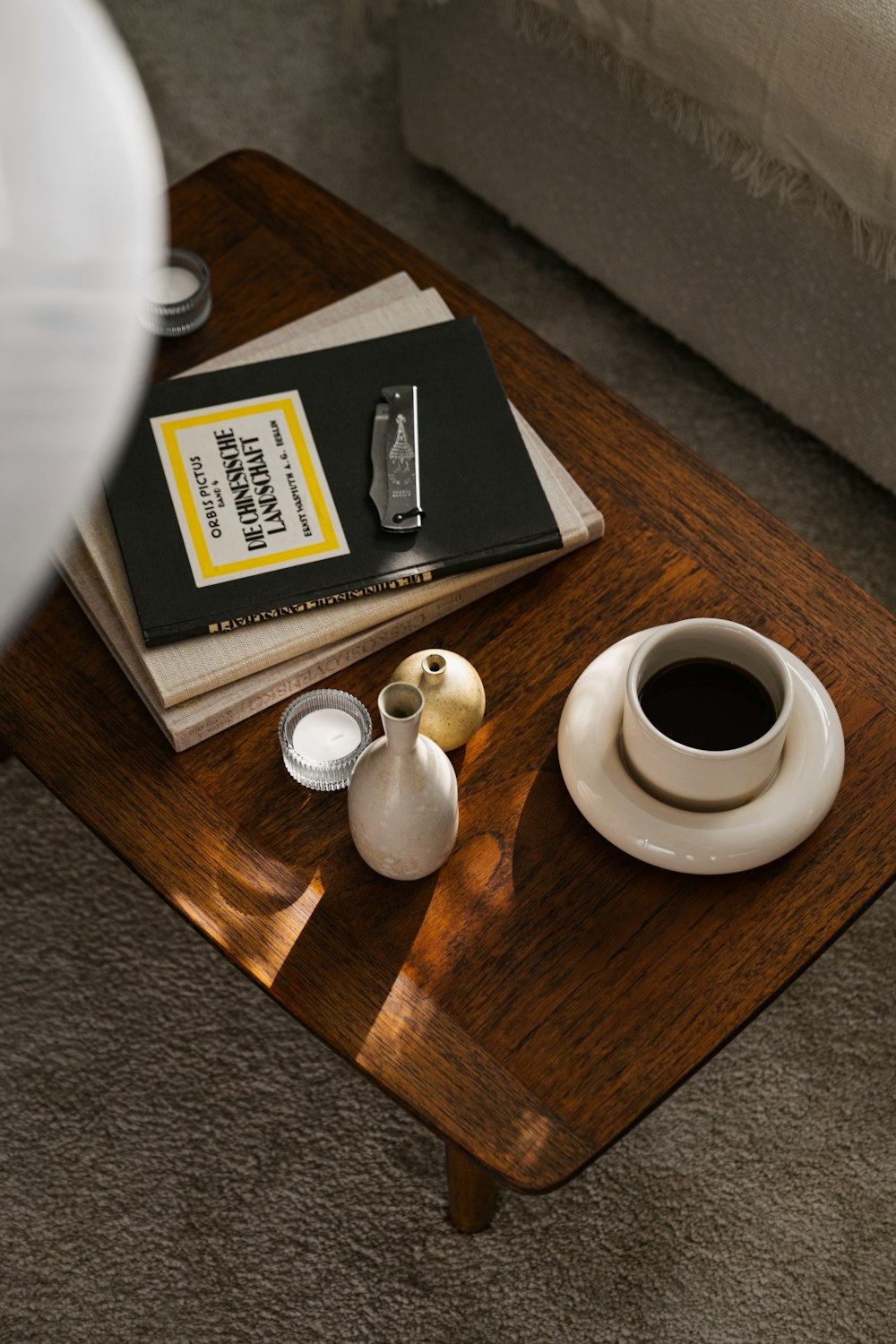 a coffee table with a book and a vase on it