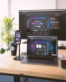 Colorful marketing materials and digital devices on a wooden desk.