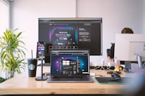 A modern workspace with marketing and travel planning tools on screens.