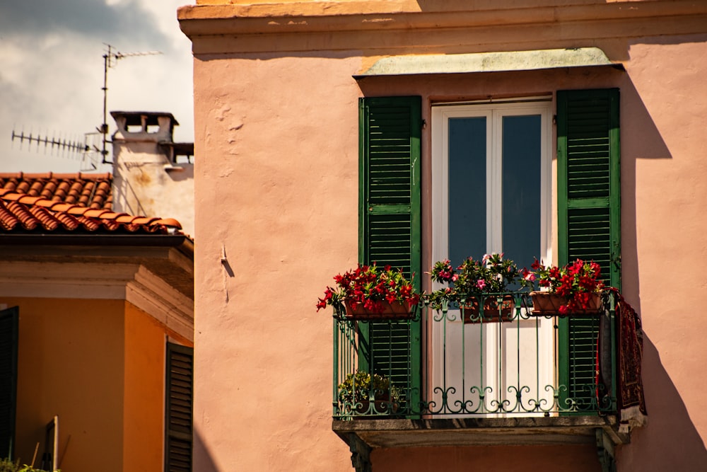 a building with a balcony with flowers on the balconies