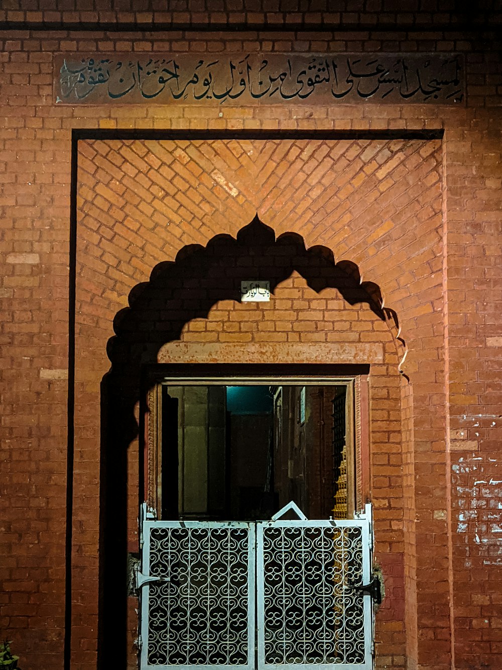 a brick building with a white gate and a brick wall