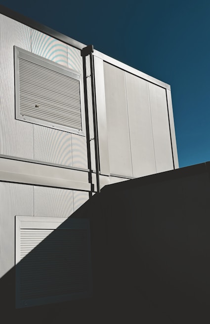 84r sun louvers casting sharp shadows on a building facade, showcasing their clean lines and durable construction