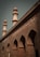 A brick building with ornate architectural details featuring pointed arches and two taller minarets. The structure has a sign labeled 'K.A. Nizami Centre for Quranic Studies' indicating its academic or religious significance.