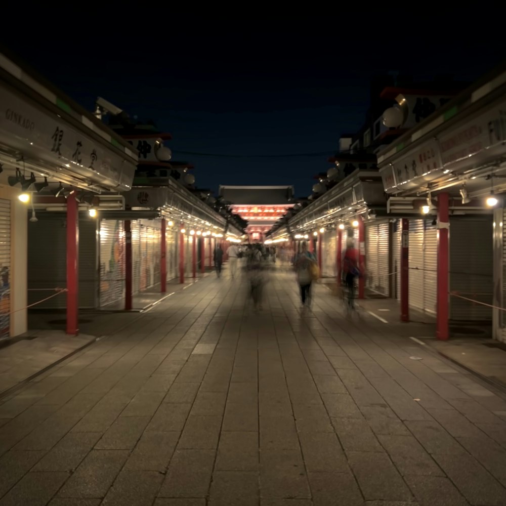 a group of people walking down a street at night