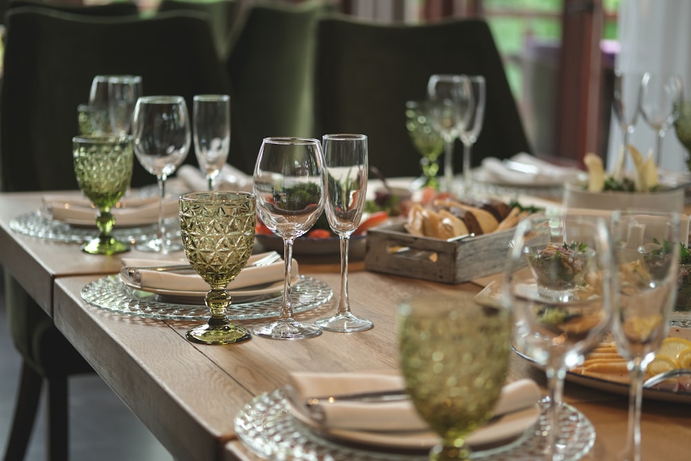 a wooden table topped with lots of glasses