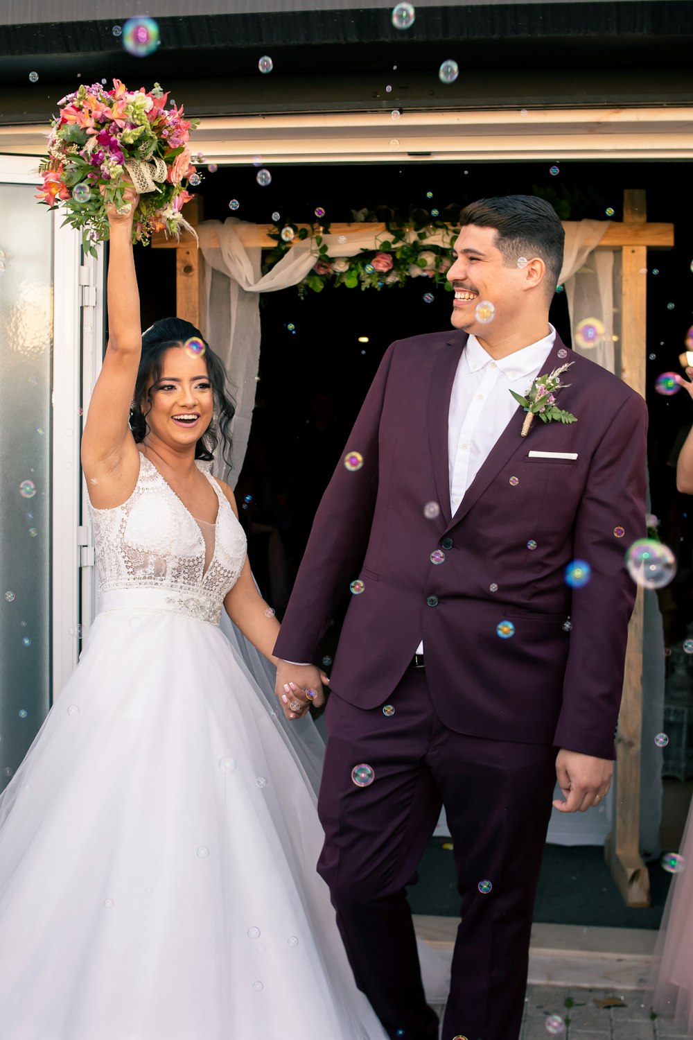 a bride and groom are walking through bubbles