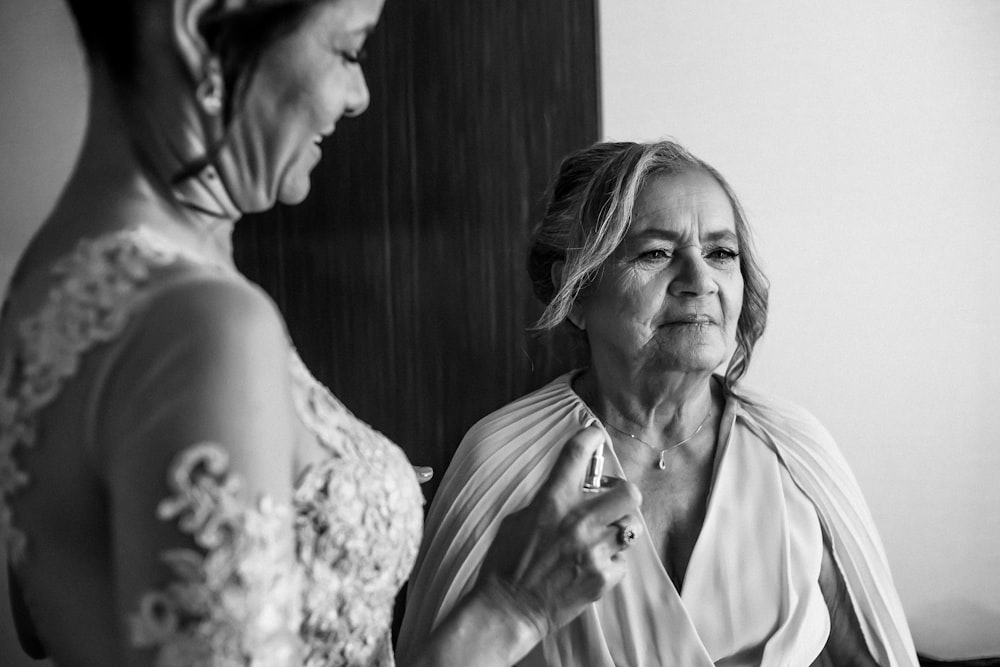 a woman standing next to another woman in a room