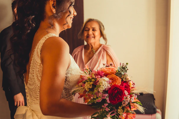 An emotional embrace between the bride and her mother, framed by traditional decor.