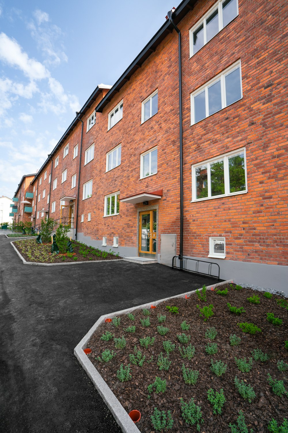 a red brick building with a parking lot in front of it