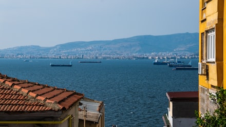 Yamaçtan körfeze bakan konut dokusu, kiremit çatılar ve apartmanlar