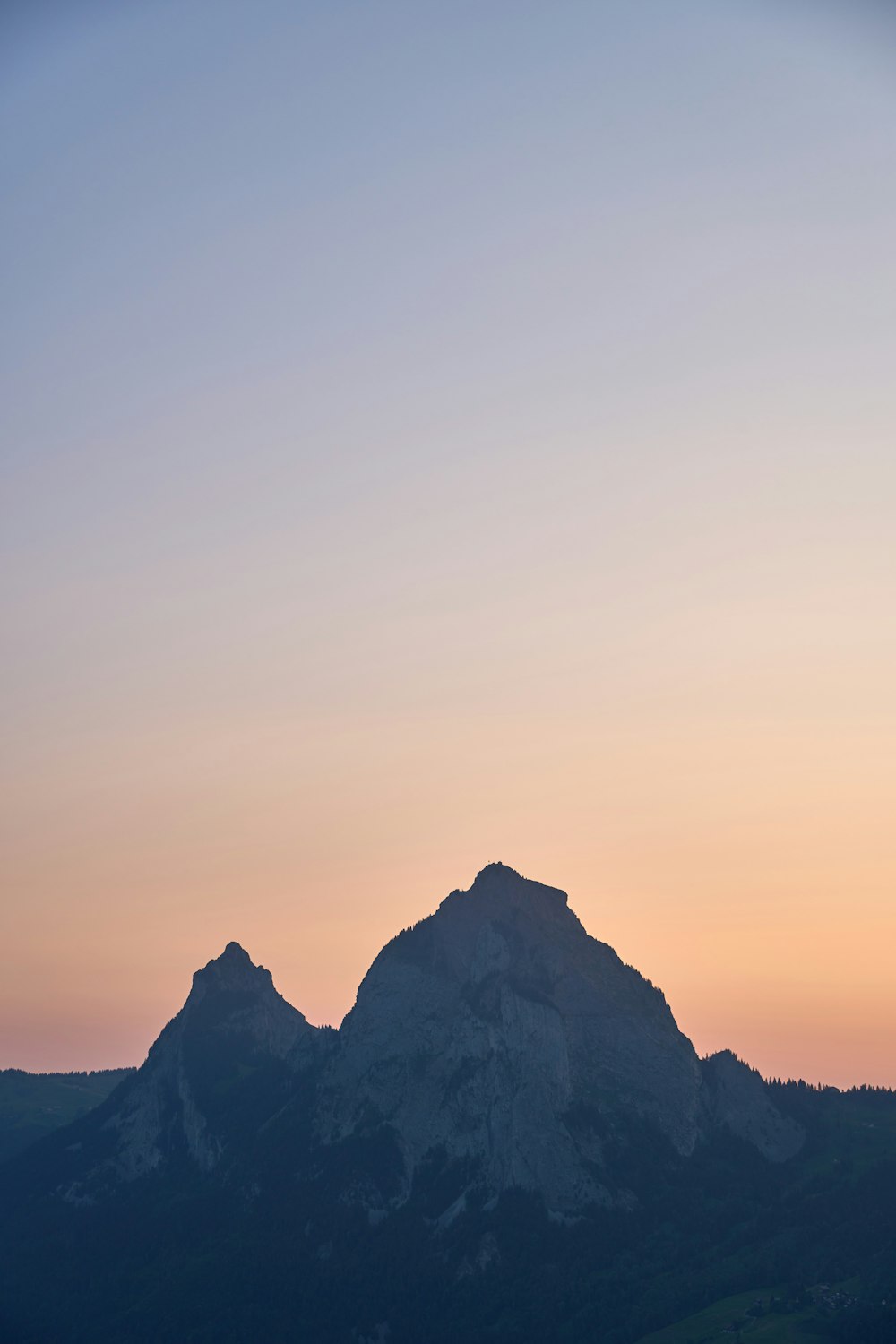 a bird flying over a mountain with a sunset in the background