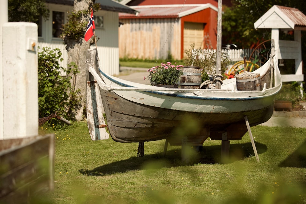 a boat sitting on top of a lush green field