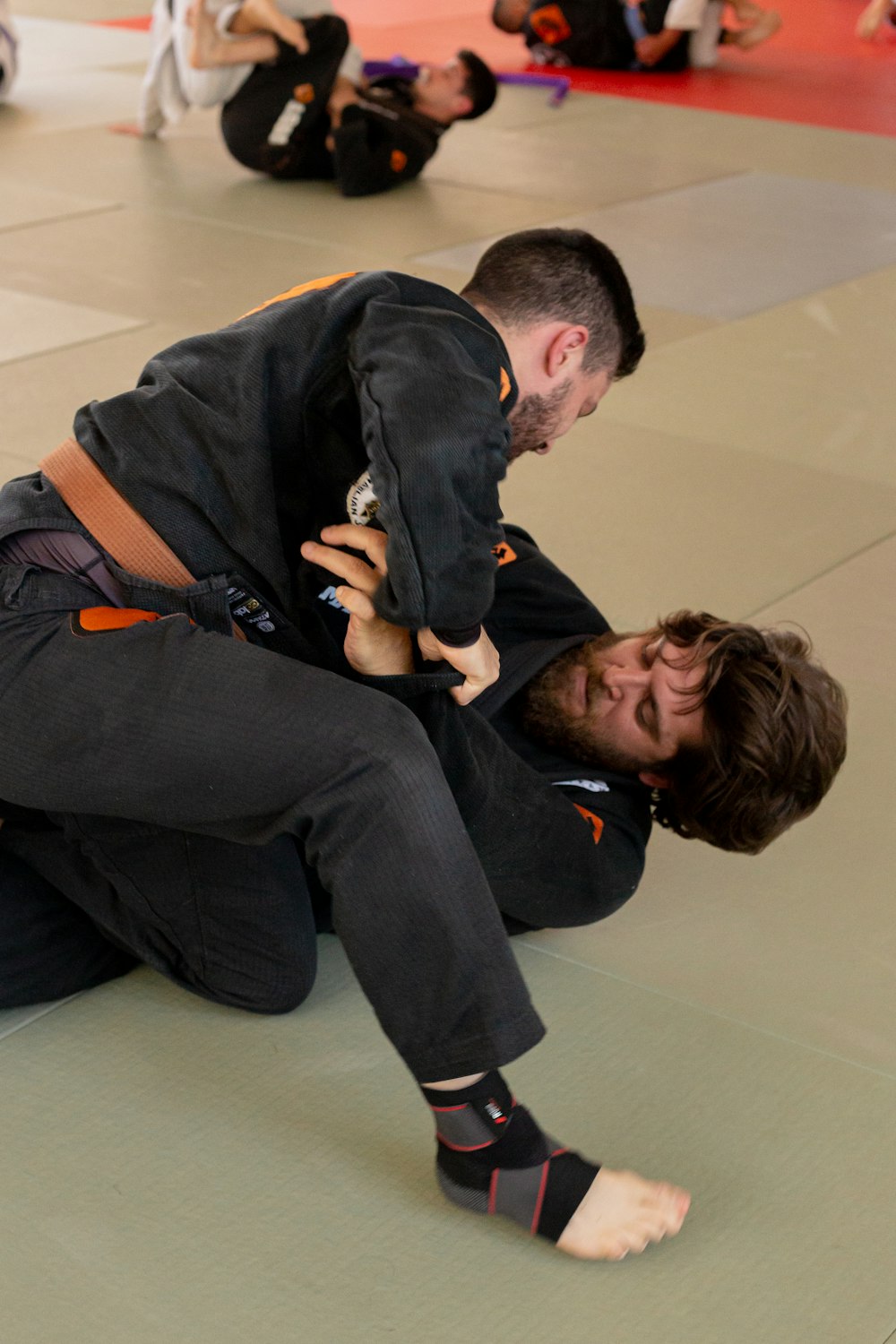 a man in a black shirt is holding a man in a black suit