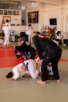 Photo of a busy jiu-jitsu class with students practicing techniques under instructor guidance.