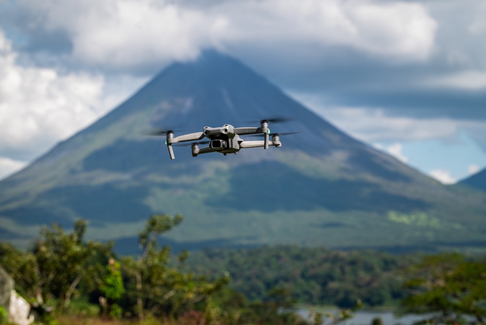 a remote controlled airplane flying in front of a mountain