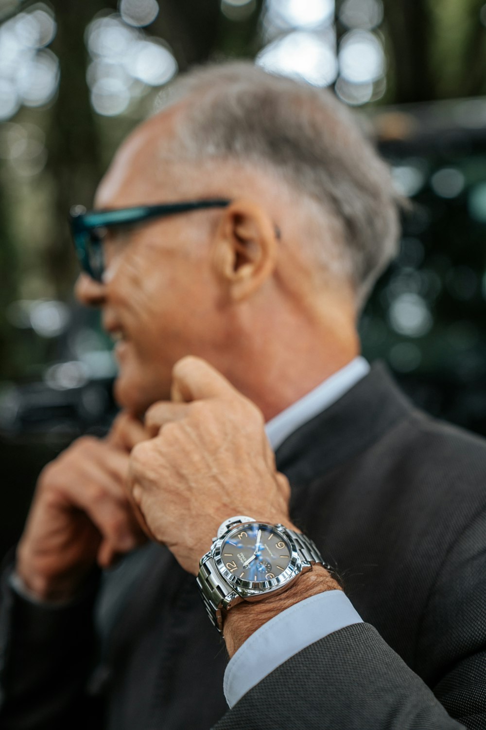a man in a suit and glasses is looking away from the camera