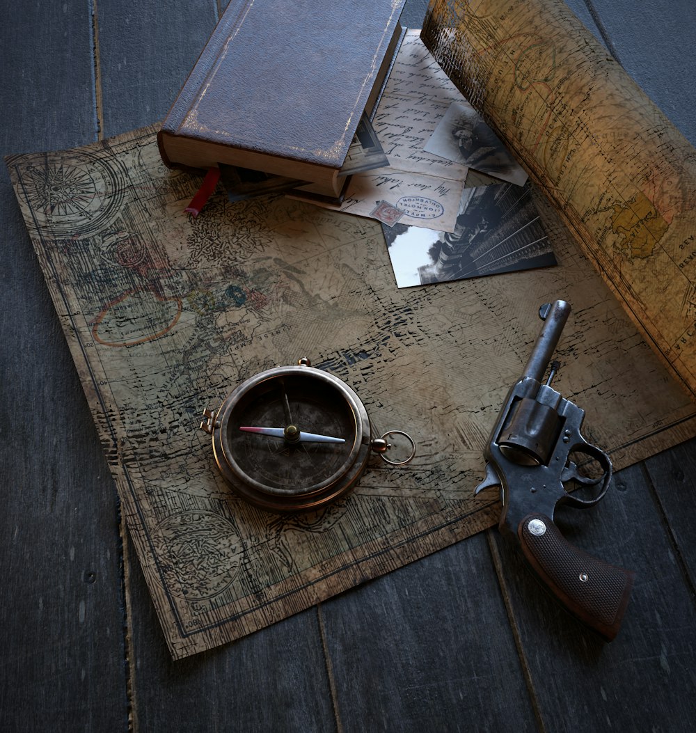 a gun, a compass, and a book on a map