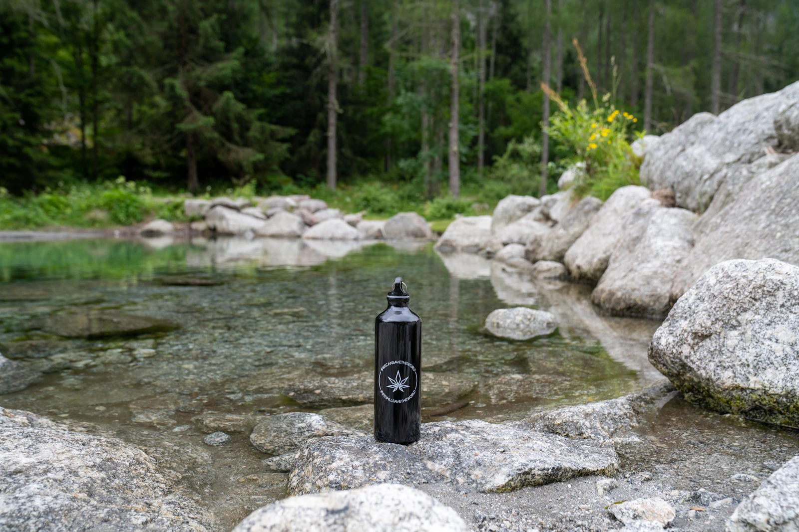 Botella sobre las rocas de un río de montaña