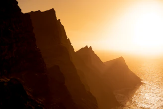 Golden sunset casting warm light over Kelingking Beach’s dramatic cliffs