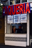 A lively shot of the taquería 'tu tako' storefront near Monumento a la Revolución, with colorful signage.