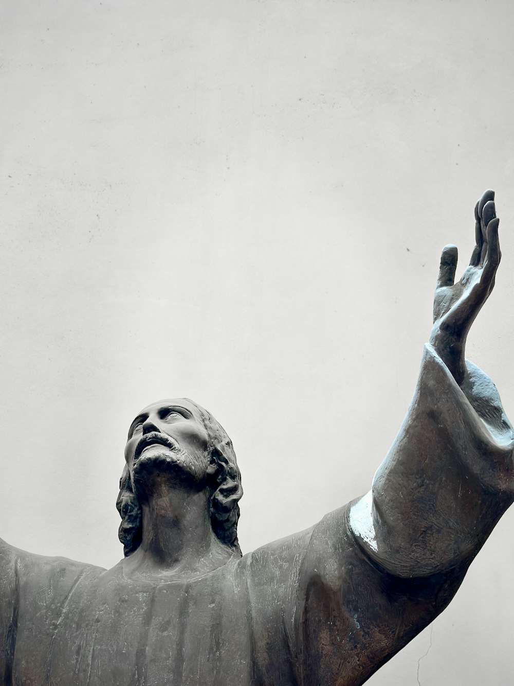 a statue of a man holding his hands up