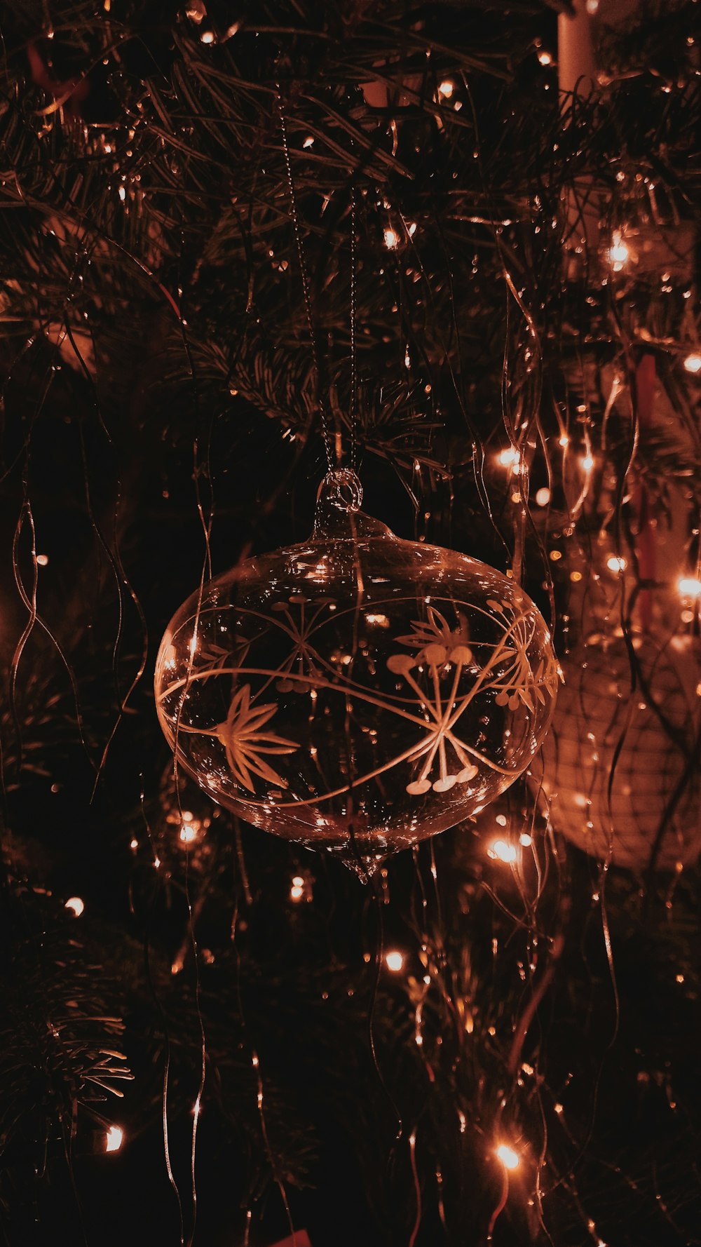 a glass ornament hanging from a christmas tree