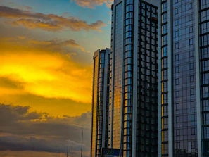 Glass skyscrapers in Mumbai tinted subtly with vibrant orange hues at sunset.