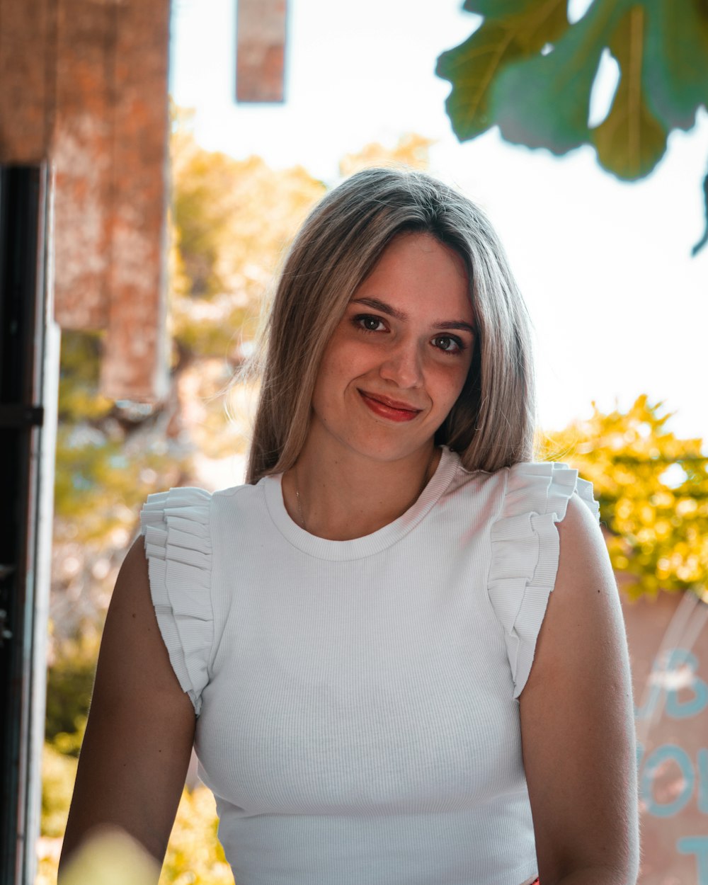 a woman in a white top is posing for a picture