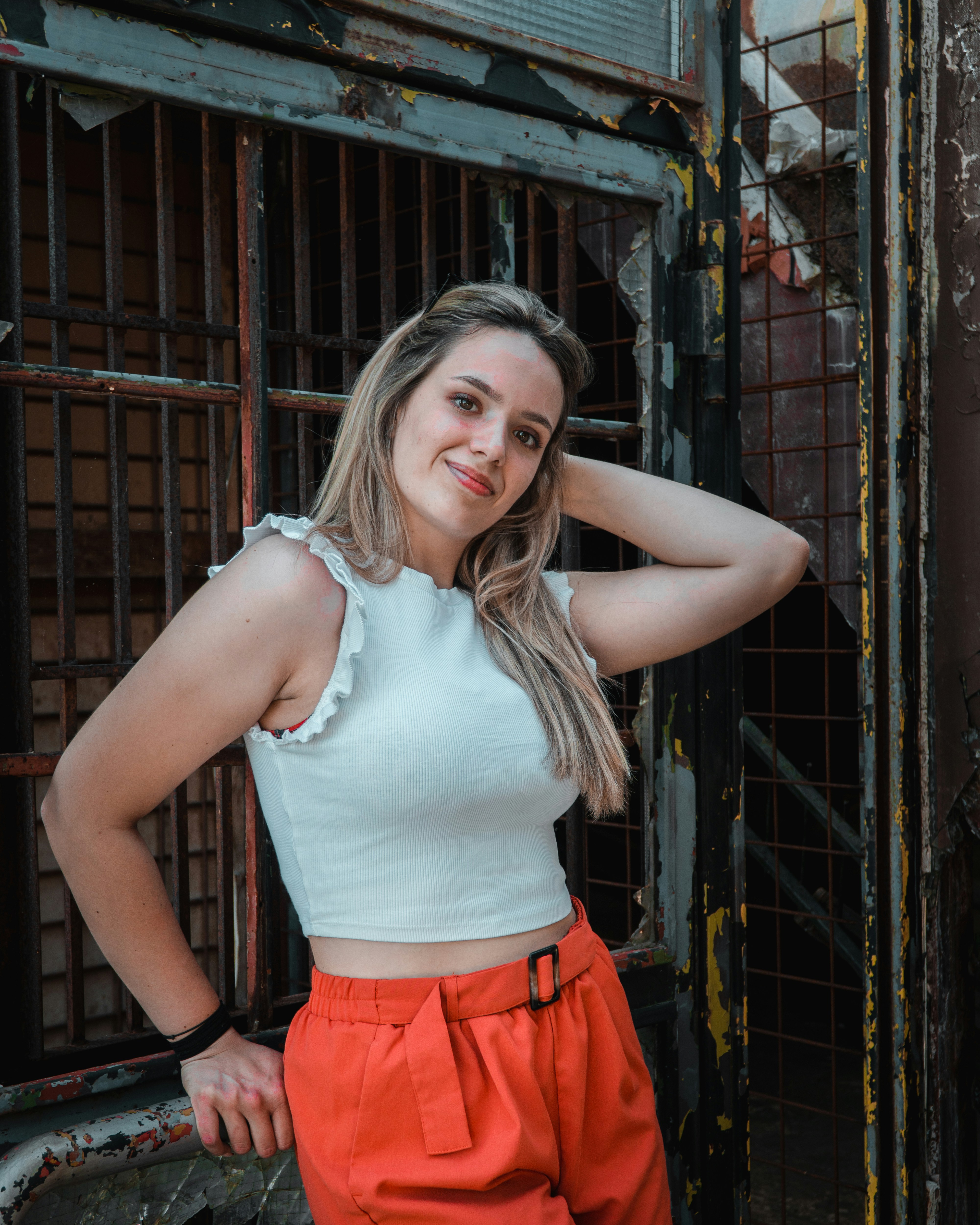 a woman posing for a picture in front of a jail cell