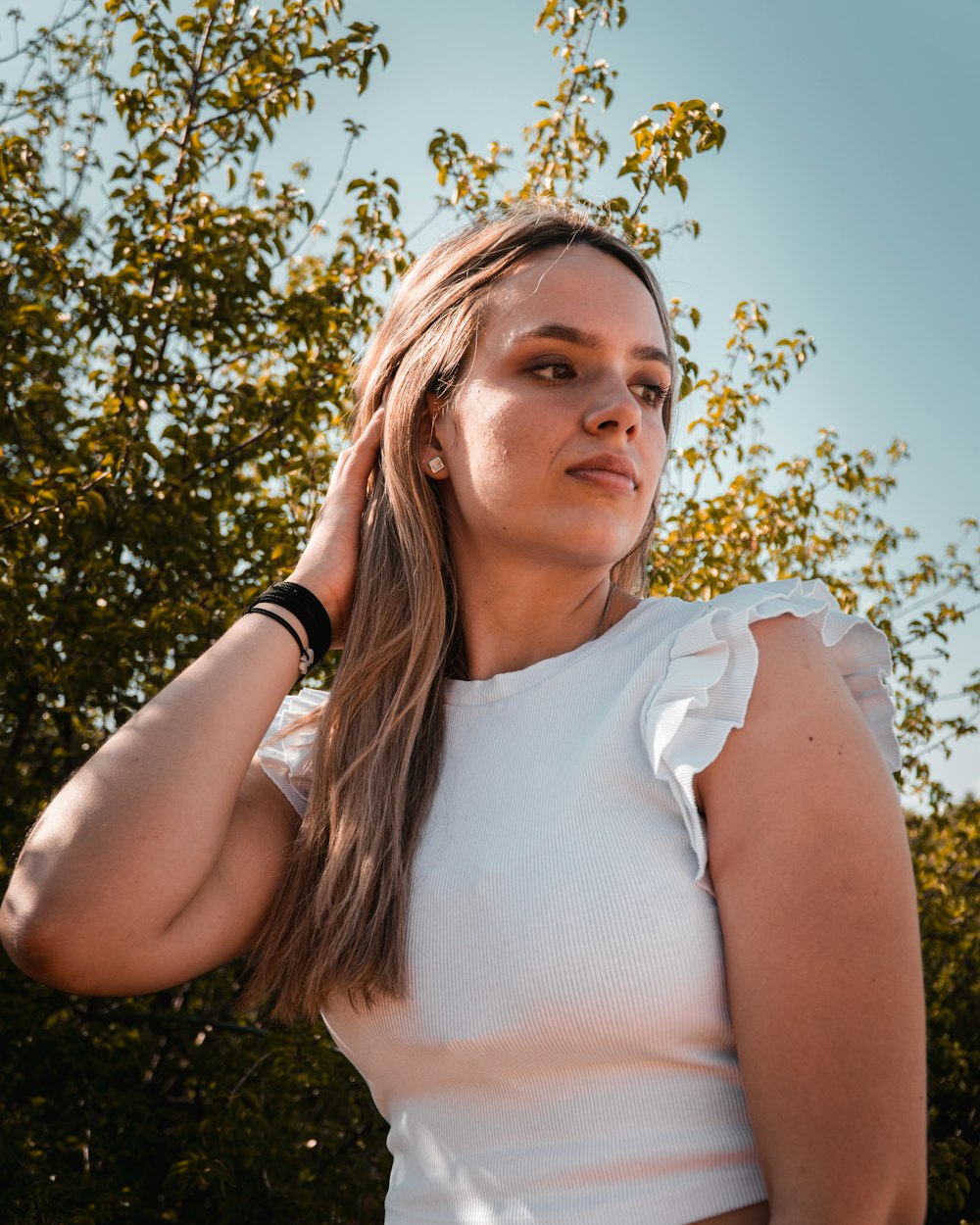 a woman with long hair wearing a white top