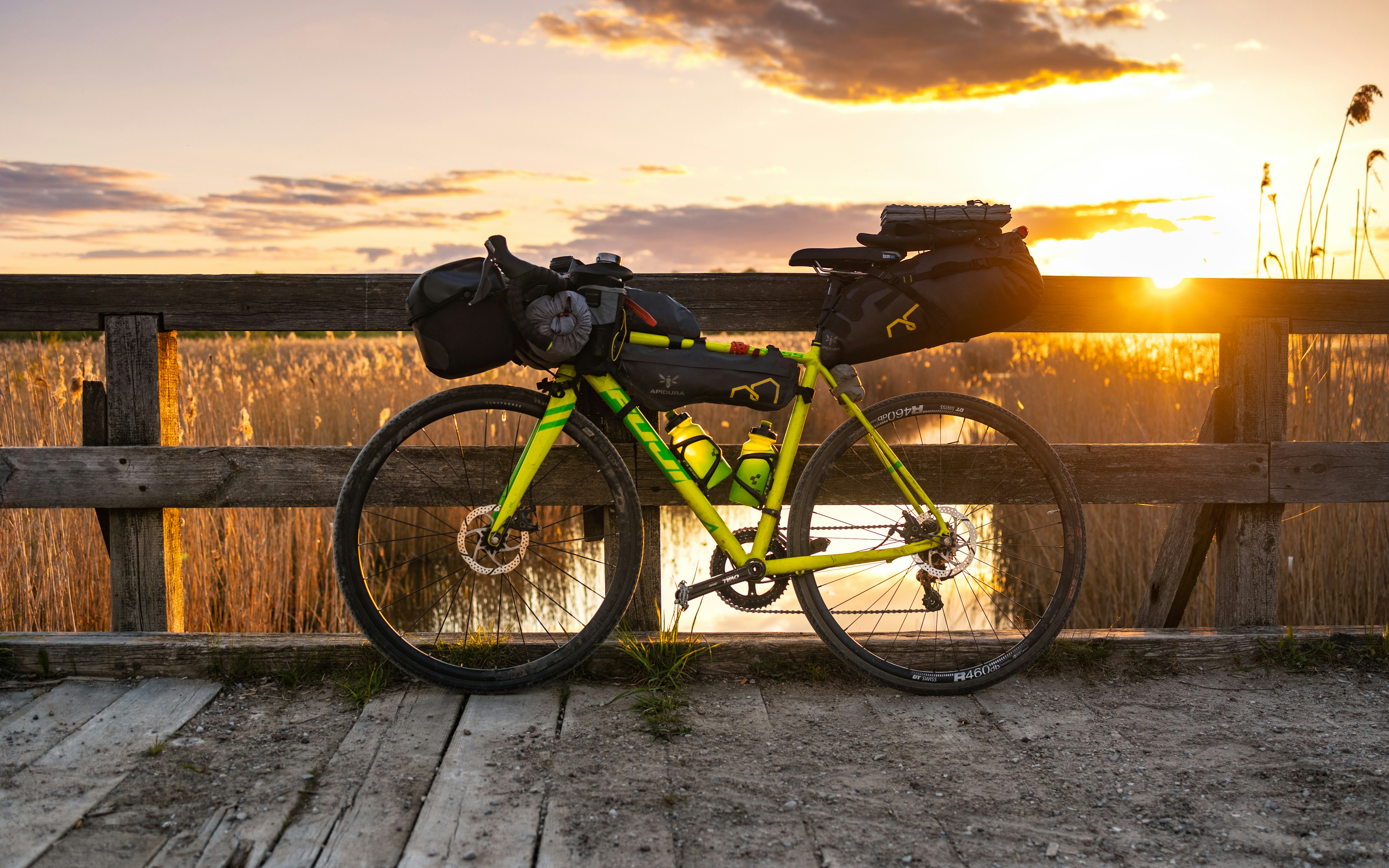 a yellow bicycle parked on a wooden bridge