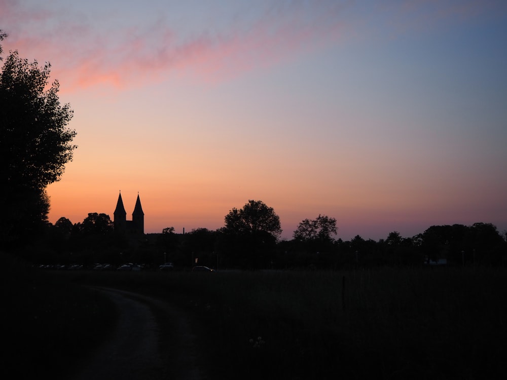 a sunset view of a church and trees