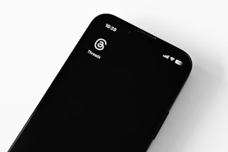 A smartphone displaying the Meshtastic app interface with a map and message threads.