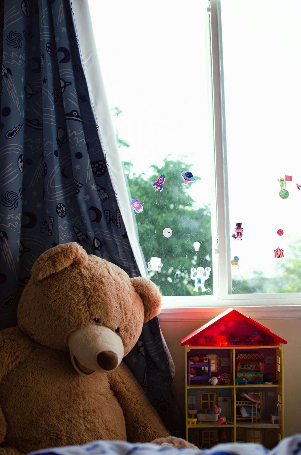 a brown teddy bear sitting next to a window